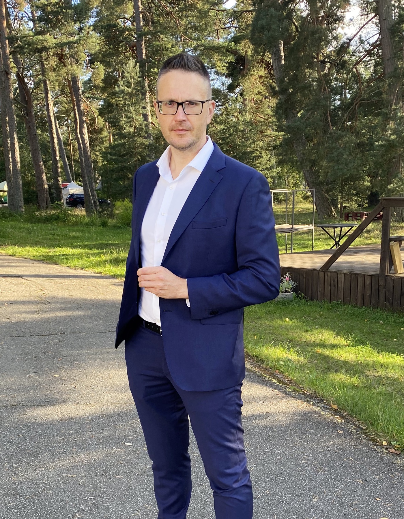 Arvo Juhkov sinises ülikonnas männimetsa taustal